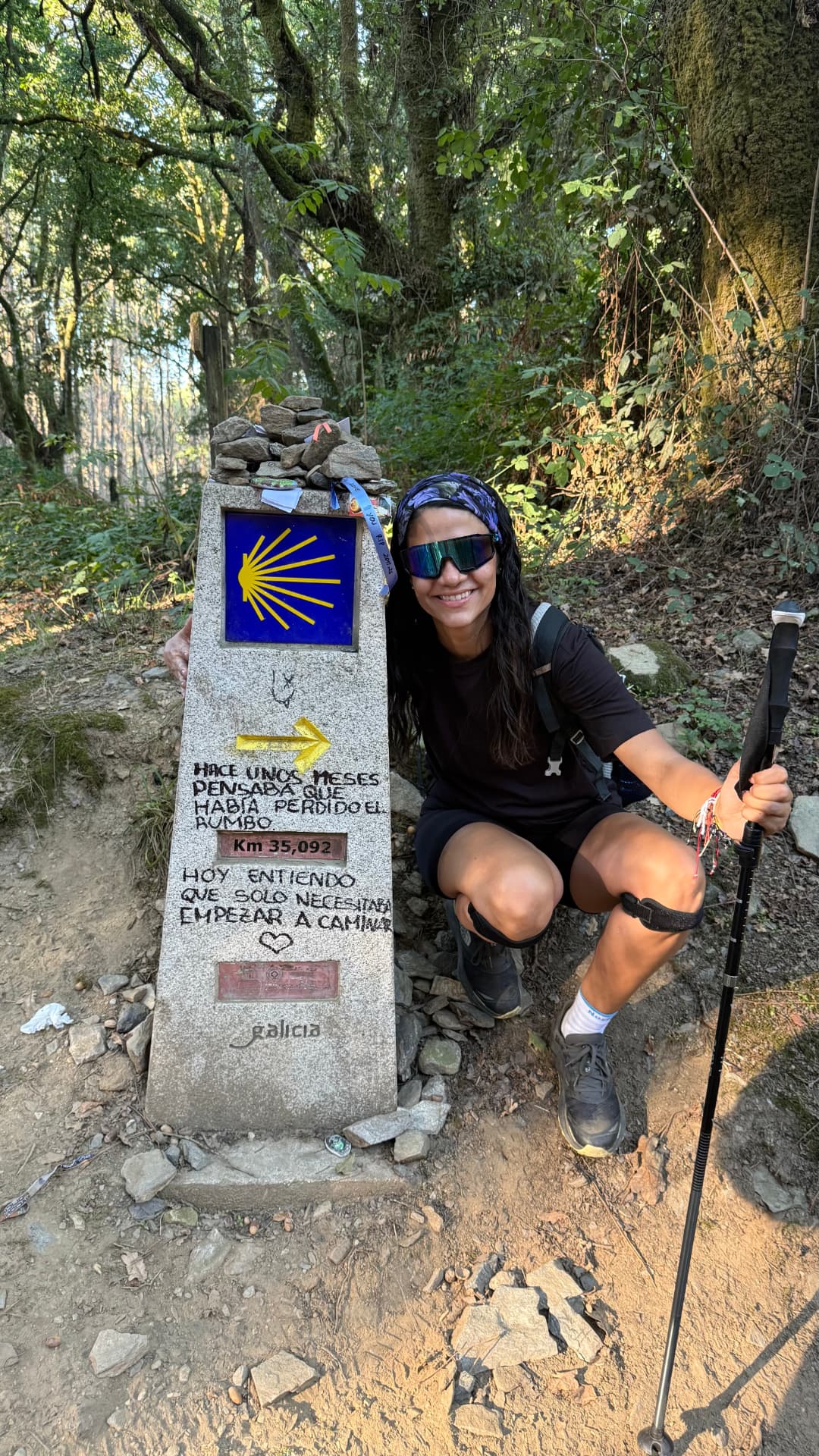Ana Lucía Cevallos arrodillada junto a un mojón del Camino de Santiago